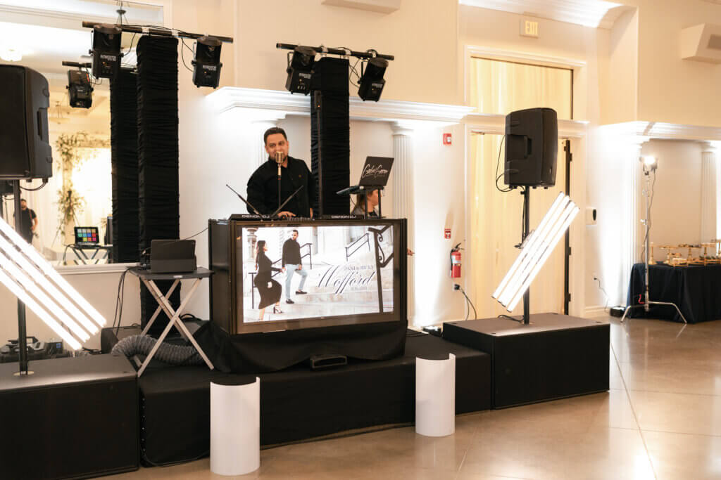 Gabriel a Bakersfield DJ of The Social Vibe with wedding setup announces cocktail hour to guests.