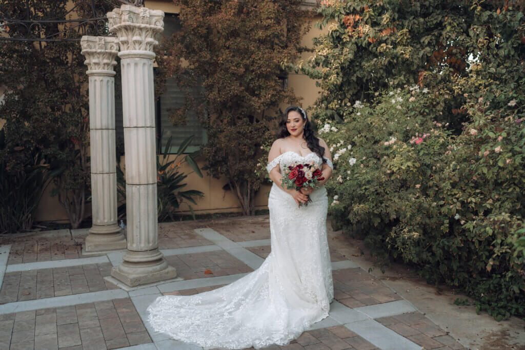 Bakersfield bride having her wedding portraits taken at a charming gazebo surrounded by lush fall foliage at an elegant wedding venue.