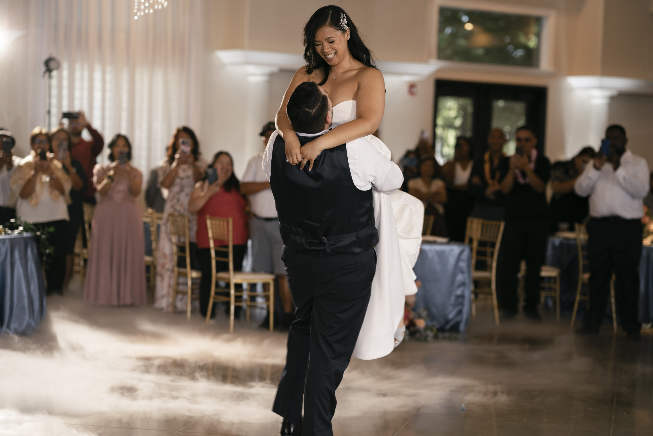 Groom lifts up bride during their first dance