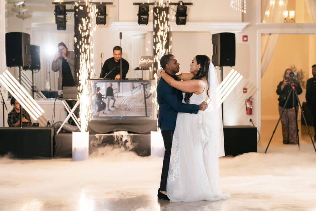 Couple dancing on a cloud with cold sparks with best wedding dj at an indoor wedding place in Bakersfield all-inclusive wedding packages