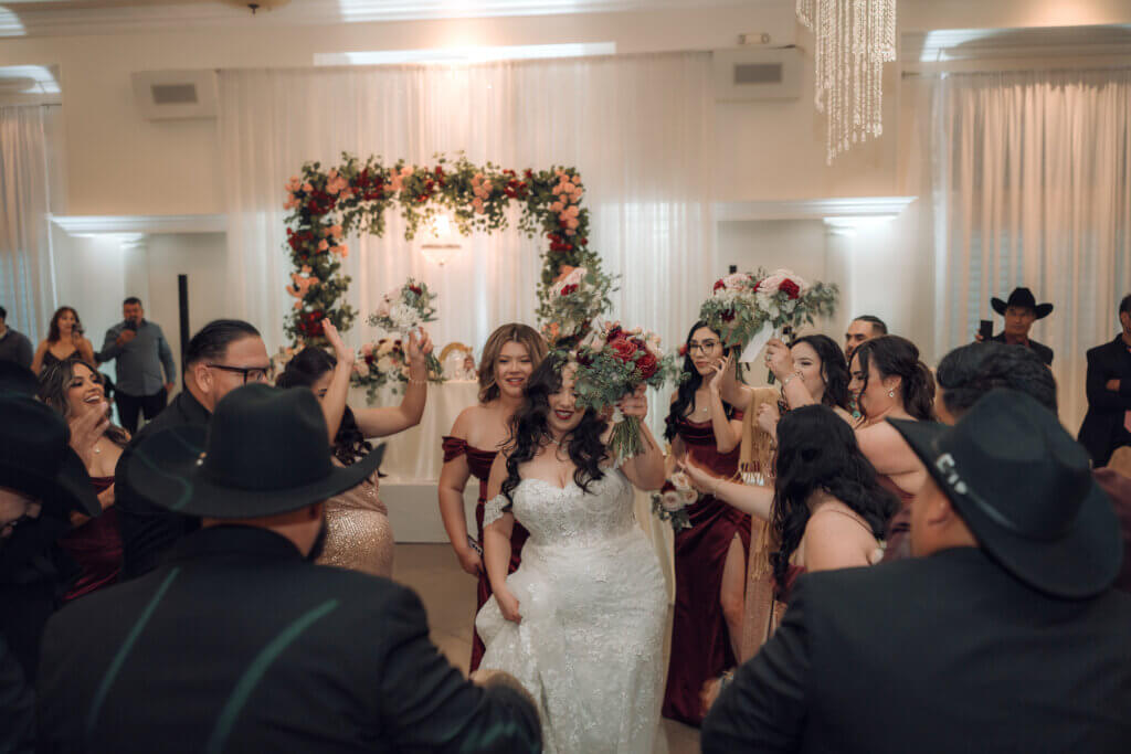 Wedding party grand entrance at an indoor Bakersfield reception hall. The wedding features blush, ivory and burgundy color palette.
