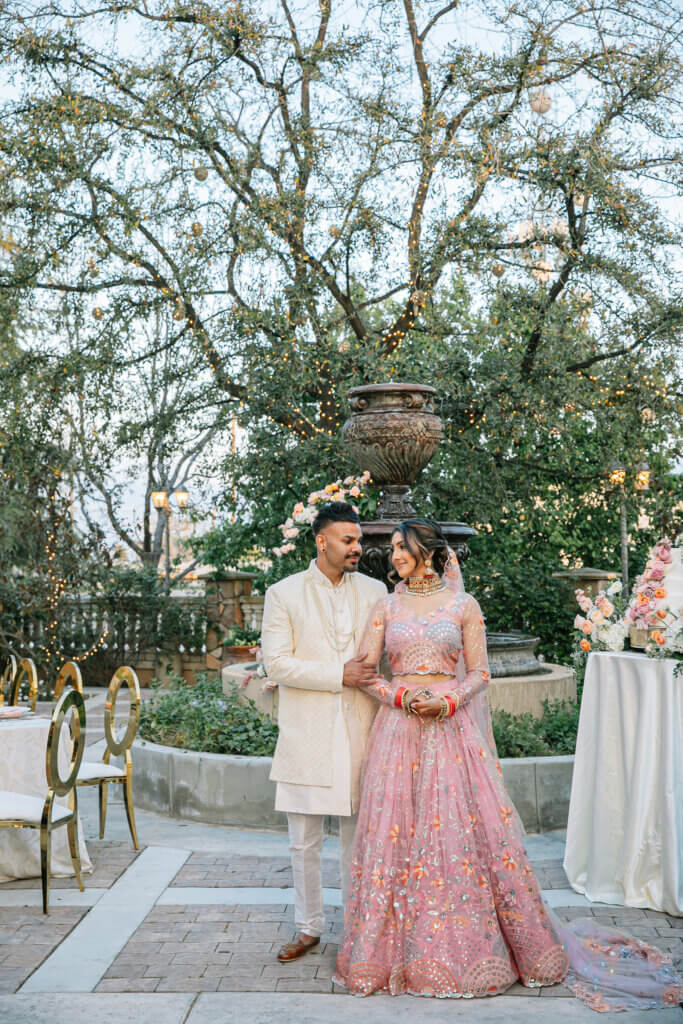 Bride and groom taking their wedding portraits in the garden courtyard during their Bakersfield Indian wedding reception