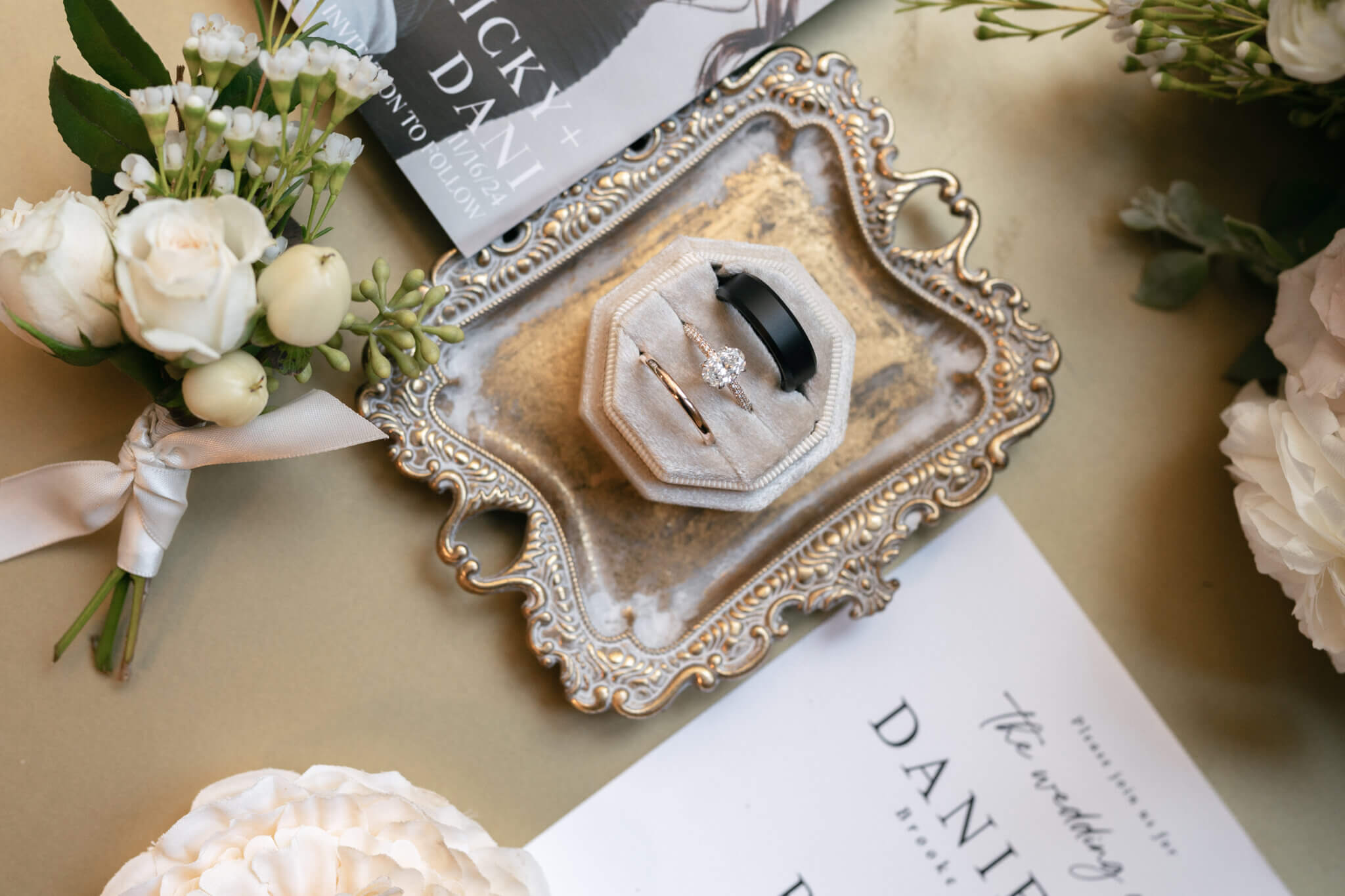 Bakersfield fall wedding flat lay with groom's boutonniere and wedding rings in a velvet ivory ring box.