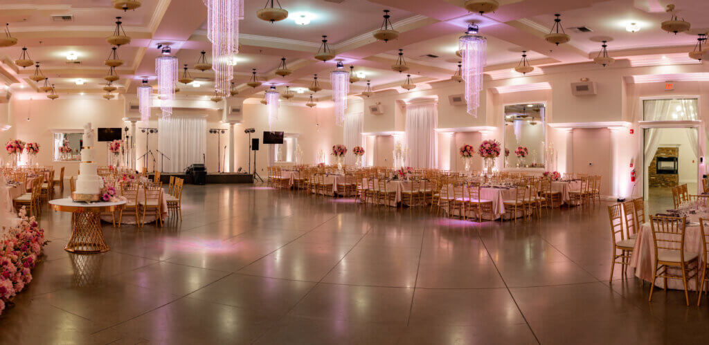 Indoor Bakersfield quinceañera venue salon de fiesta spacious layout featuring square guest tables and a live band stage.