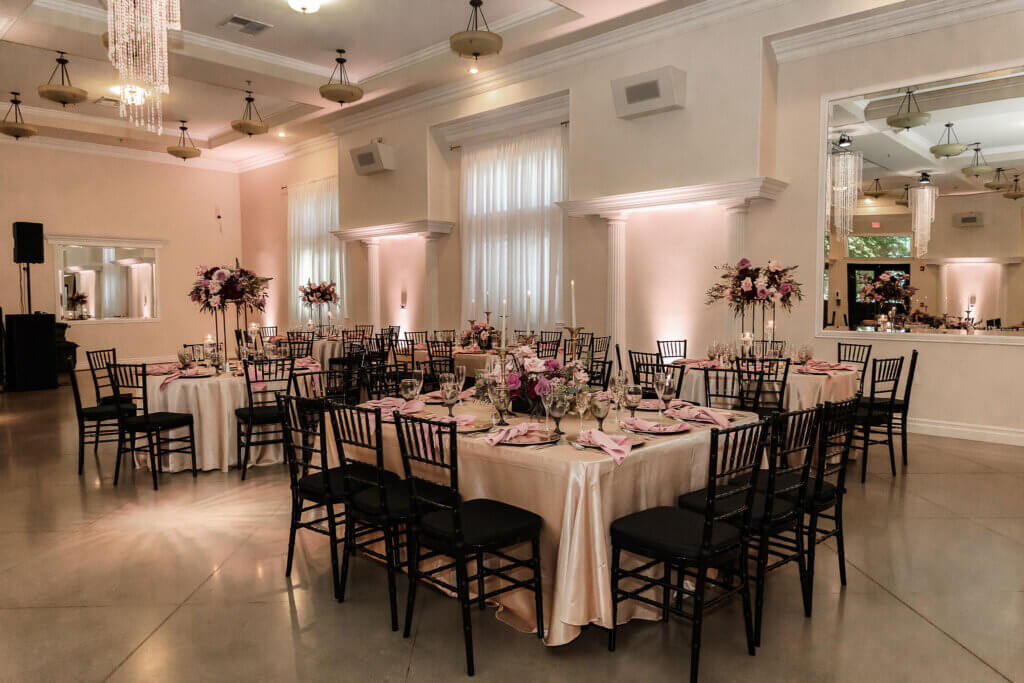 Elegant Bakersfield quinceañera salon de fiesta featuring black chiavari chairs, champagne table linens, and flowers in mauves, pinks, and burgundy 